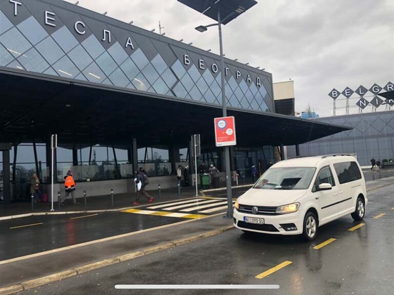 a white car in front of the airport