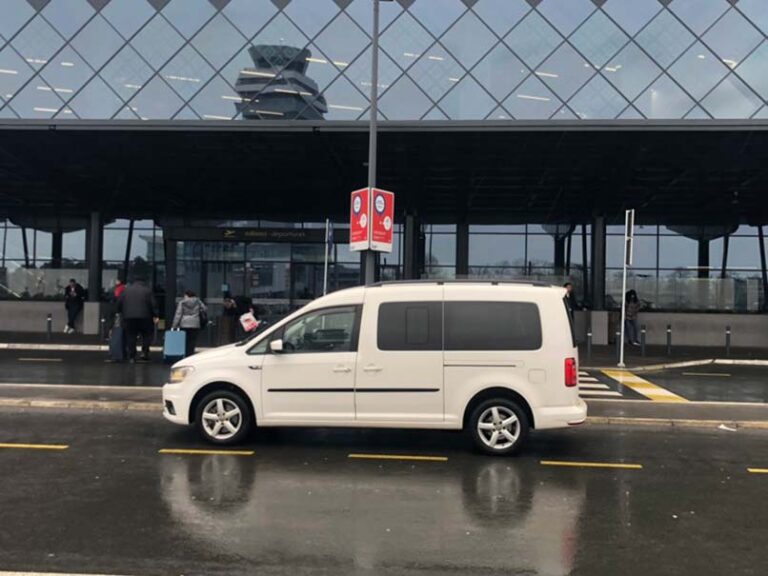 a white car in front of the airport