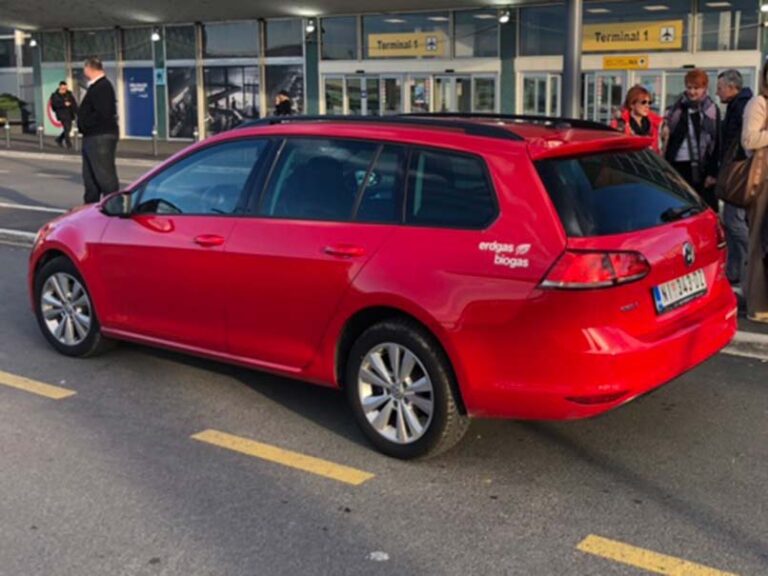 a red car in front of the airport